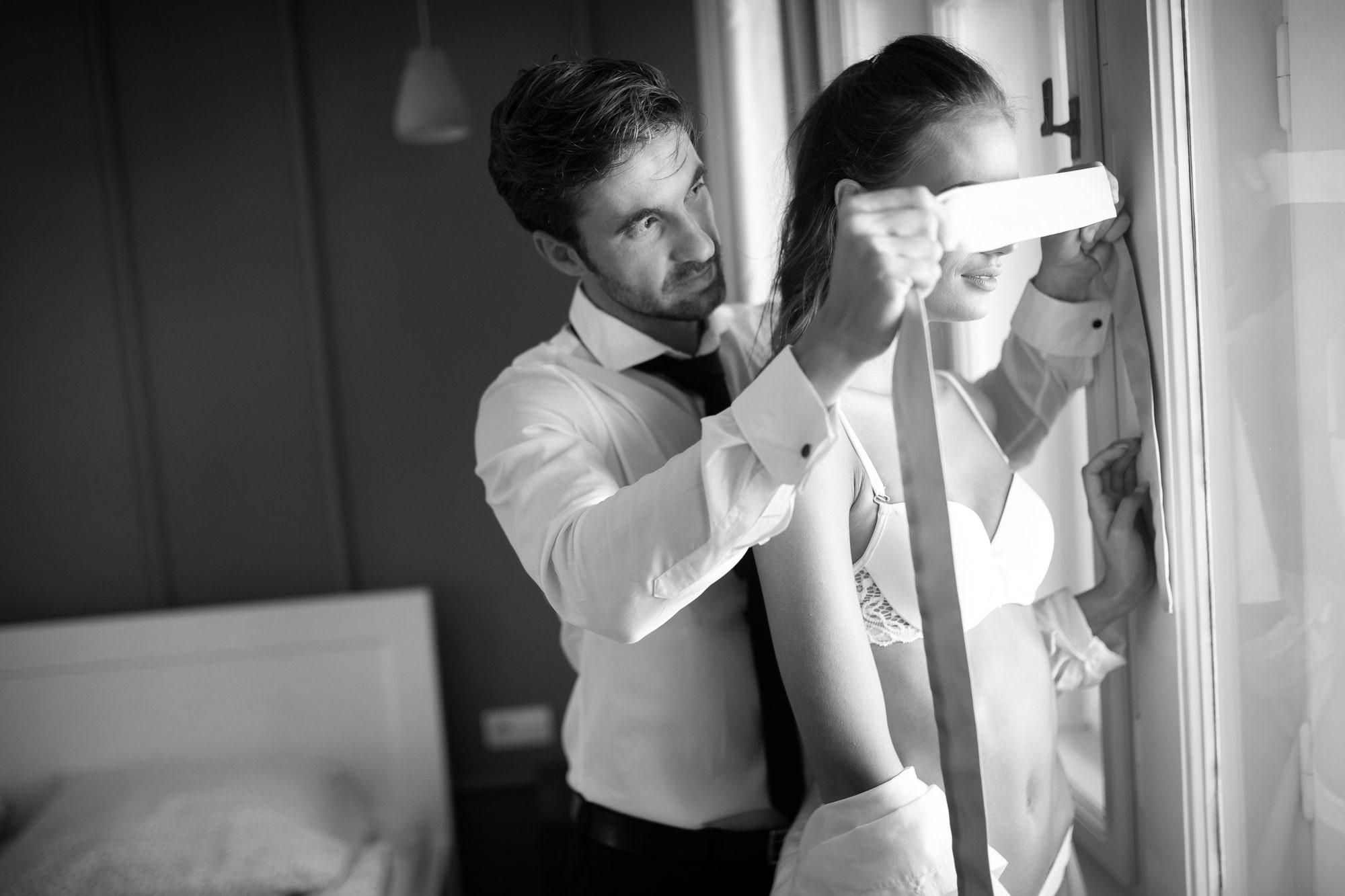 Man blindfolding a woman